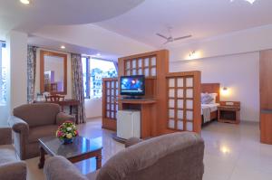 a living room with a couch and a tv in a room at Nanutel Margao in Madgaon