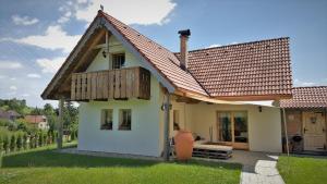 ein kleines weißes Haus mit einem Holzdach in der Unterkunft Chalupka na Orave in Dolný Kubín
