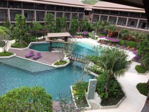 a patio with a pool and lawn chairs at Maehaad Bay Resort - SHA Plus in Mae Haad