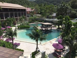 a resort pool with a picnic table and chairs at Maehaad Bay Resort - SHA Plus in Mae Haad
