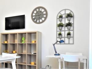 a living room with a clock and a table and chairs at Casa Panco in Syracuse