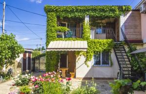 a building covered in green ivy with a staircase at Solnechnaya 1109 in Zatoka