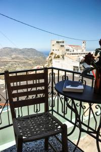 a table and a chair on a balcony with a view at Traditional Karpathian house in Karpathos Town