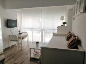 マラガにあるApartamento Malagueta Playaのベッドルーム1室(ベッド1台、テーブル、デスク付)
