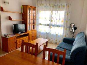 a living room with a blue couch and a tv at Apartamentos En Deltebre in Deltebre