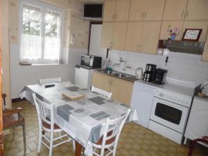 a kitchen with a table with a table cloth on it at Les Marguerites Aux Lotz in Thiers