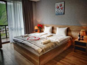 a bedroom with a large bed in a room at Sunshine Kazbegi in Stepantsminda