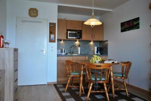 eine Küche mit einem Holztisch und Stühlen im Zimmer in der Unterkunft Frische Brise 12.02. in Cuxhaven