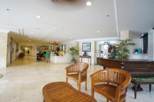 a lobby with a piano and two wooden chairs at @ Marbella Lane Mountain View Studio, steps from Wakiki Beach in Honolulu +10 photos