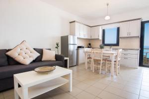 a living room with a couch and a table and a kitchen at Kimata Apartments in Arkasa