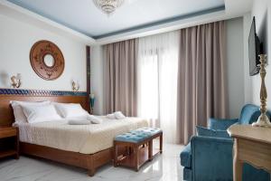 sypialnia z łóżkiem i niebieskim krzesłem w obiekcie Vener Luxury Suites w Chanii