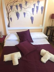 a bedroom with a bed with purple pillows at B&B Ginevra in Pisa
