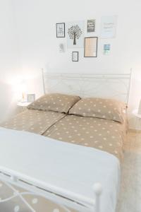 a white bed with polka dot pillows in a bedroom at LCT Charming Beach House in Hvar