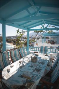 mesa con sillas y techo azul con vistas a la playa en Paroscarmel studio-apartment, en Logaras
