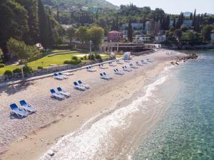 uma vista aérea de uma praia com cadeiras e água em Maistra Select Mlini Hotel em Mlini