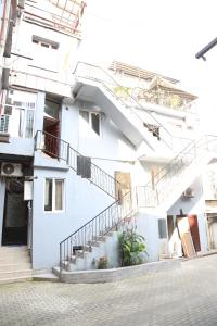 a white building with stairs and potted plants at Apartment DURU in Batumi