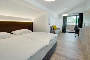 a bedroom with a large bed and a living room at Brandlhof lodge in Saalfelden am Steinernen Meer +22 photos