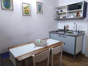 cocina con mesa, fregadero y encimera en Casetta ad Ispica, en Ispica