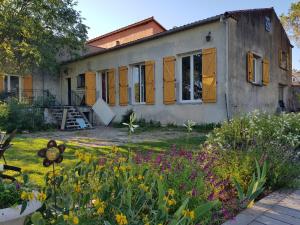 uma casa velha com flores em frente em Mas des Ballats em Saint-Bauzille-de-Putois