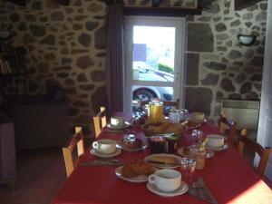 a table with a red table cloth with food on it at ferme de Lamourio in Saint-Cernin
