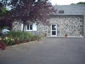 a stone house with a car parked in front of it at ferme de Lamourio in Saint-Cernin