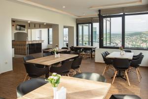 a restaurant with tables and chairs and large windows at Vista Hotel in Tbilisi City