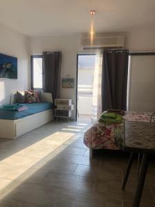 a bedroom with a bed and a table and window at AgiaNapaNest studio in Ayia Napa