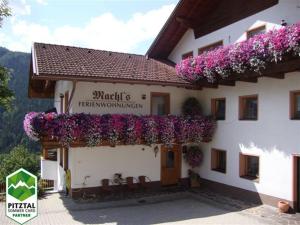 un edificio con flores a un lado. en Machls Ferienwohnungen, en Jerzens