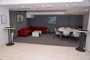 a waiting room with a red couch and a table at Hotel Alexandar II in Skopje