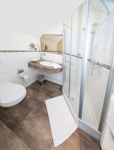 La salle de bains est pourvue d'une douche, de toilettes et d'un lavabo. dans l'établissement Gästehaus fliegendes Perlhuhn Borgfeld, à Lilienthal