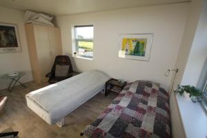 een slaapkamer met een bed en een stoel erin bij Hellerup Bed & Breakfast in Løgstrup