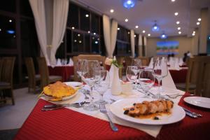 a table with plates of food and wine glasses at Haile Resort Arbaminch in Migie