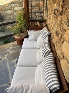 un grupo de almohadas alineadas contra una pared de piedra en Portugal Mountain Splendour - Xisto village en Tarrastal