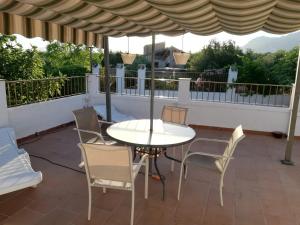 un patio con mesa, sillas y sombrilla en Cortijo Los Abedules, en Cazorla