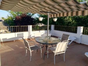 a patio with a table and chairs under a pergola at Cortijo Los Abedules in Cazorla