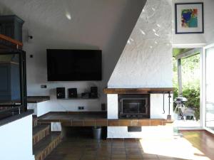 a living room with a fireplace and a flat screen tv at Ferienhaus 956 in Biersdorf am See