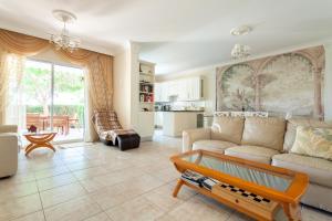 uma sala de estar com um sofá e uma mesa em Kings Apartment with private Garden em Pafos