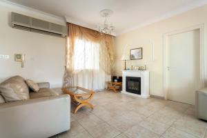 a living room with a couch and a fireplace at Kings Apartment with private Garden in Paphos City