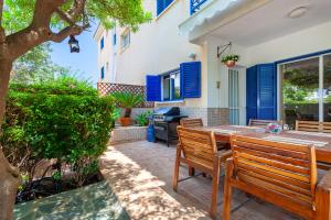 eine Außenterrasse mit einem Holztisch und Stühlen in der Unterkunft Kings Apartment with private Garden in Paphos City