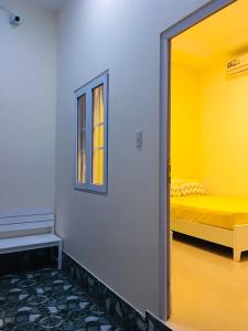 a room with a yellow bed and a window at Homestay BONO Mũi Né in Phan Thiet