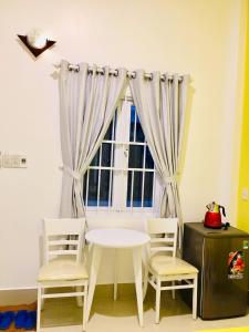 a white table and chairs in front of a window at Homestay BONO Mũi Né in Phan Thiet