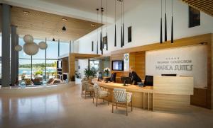a lobby with a woman sitting at a desk at Marea Suites, Valamar Collection in Poreč