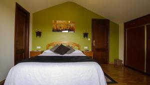 a bedroom with a large bed with green walls at Tolare-Berri in Zestoa