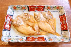 dos peces en un plato en una mesa en Izumo Royal Hotel en Izumo