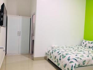 a white bedroom with a bed and a closet at Homestay BONO Mũi Né in Phan Thiet