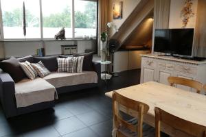 a living room with a couch and a table at Appartementen Het Oude Atelier in Schoorl