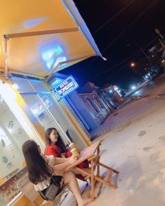 a woman sitting in a chair on the beach at night at Homestay BONO Mũi Né in Phan Thiet