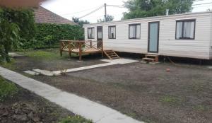 a white mobile home with a porch and a porch at Kupai Apartman in Tiszaújváros