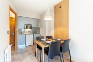 a kitchen and dining room with a table and chairs at Aparthotel El Serch in Andorra la Vella