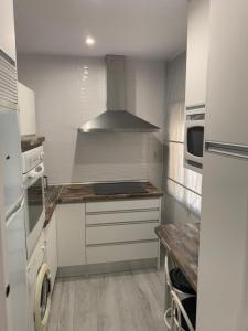 a kitchen with white cabinets and a stove top oven at ALOJAMIENTO CERRO DEL CABEZO in Andújar +6 photos